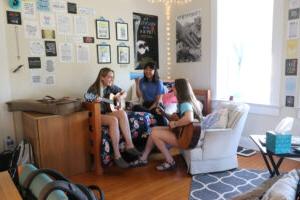 Students playing guitars together in a dorm room